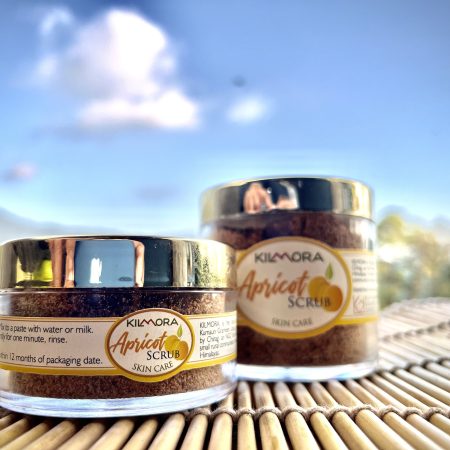 Two jars with gold lids with labels that say Apricot Scrub