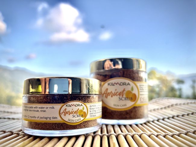 Two jars with gold lids with labels that say Apricot Scrub