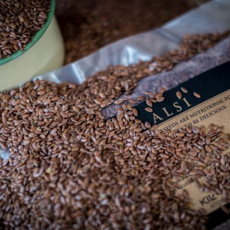 Close up of flaxseed or alsi with a packet of flaxseed in the background