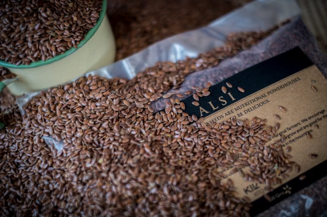 Close up of flaxseed or alsi with a packet of flaxseed in the background