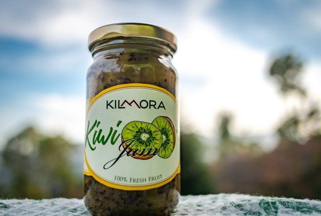 Jar of Kilmora Kiwi Jam with blue skies in the background