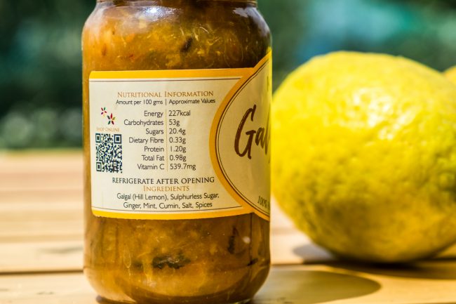 Galgal (Hill Lemon) Chutney bottle displayed against the sky with a hill lemon
