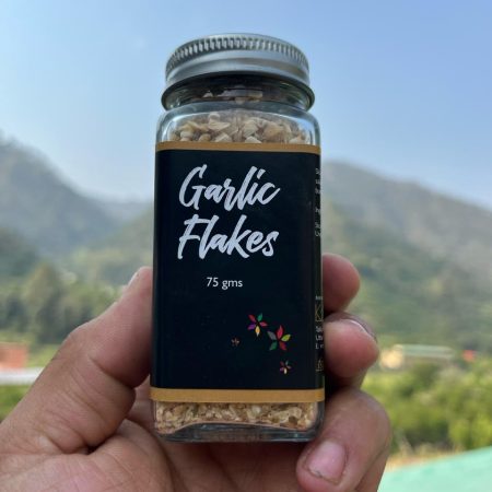 Glass jar with Garlic flakes printed on it. Held up against the sky.