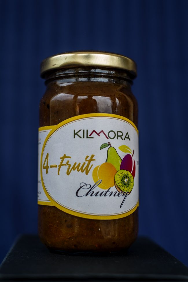 Glass jarof Kilmora Four Fruit Chutney on a blue background