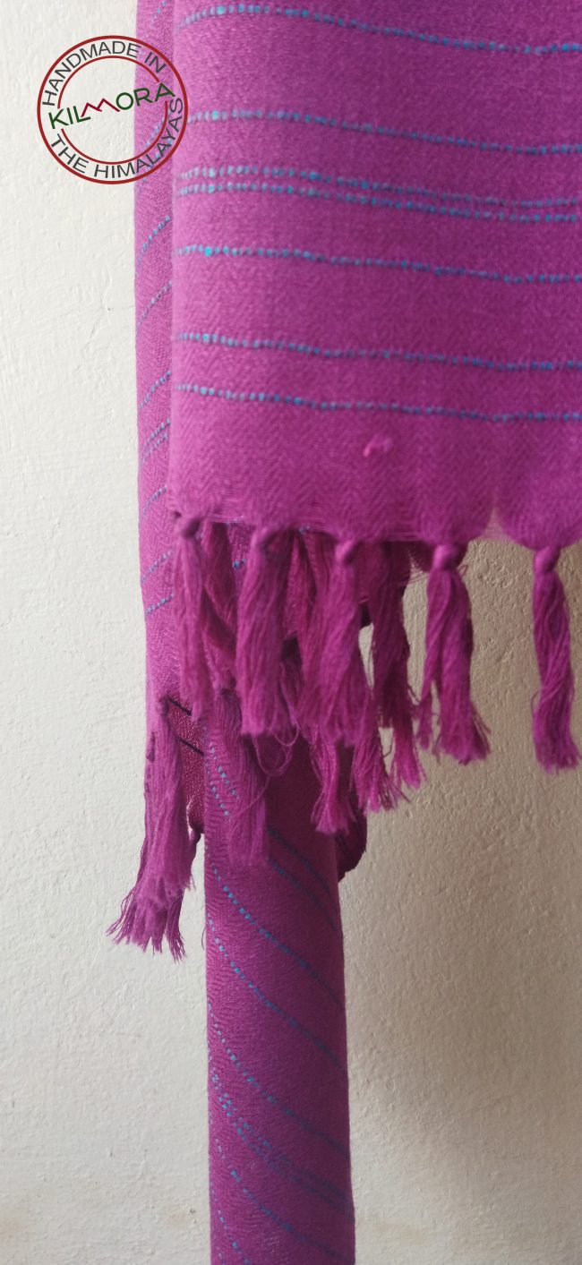 Handwoven shawl from Kilmora with fuchsia pink with subtle turquoise blue vertical stripes at the border. Guaranteed to brighten up a dull winter day or mood.