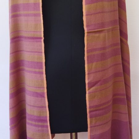 Handwoven pure merino wool shawl from Kilmora with varied vertical stripes in shades of deep rouge and ochre, edged with a thin border of salmon pink.