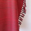 Handwoven pure merino wool shawl from Kilmora in ruby red with graduated thin horizontal stripes in black in the bottom half.