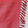 Handwoven pure merino wool shawl from Kilmora in ruby red with graduated thin horizontal stripes in black in the bottom half.