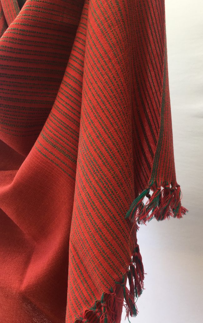Merino wool shawl with sage green vertical stripes giving way to solid tomato red block at the bottom