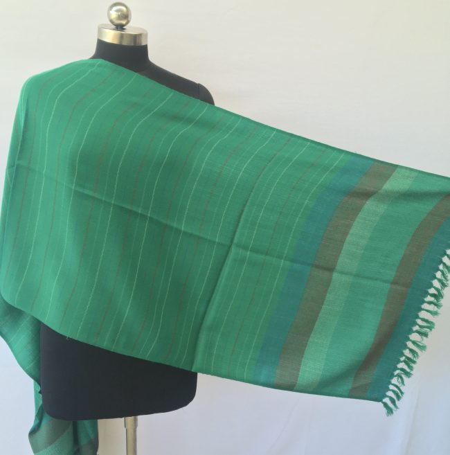 Jade coloured merino wool stole from Kilmora. With an end border with vertical stripes of teal, double shaded mix of moss green and orange