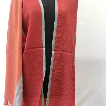 Bold, variegated stripes in tomato, orange, red and grey make up this merino wool shawl from Kilmora