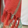 Bold, variegated stripes in tomato, orange, red and grey make up this merino wool shawl from Kilmora
