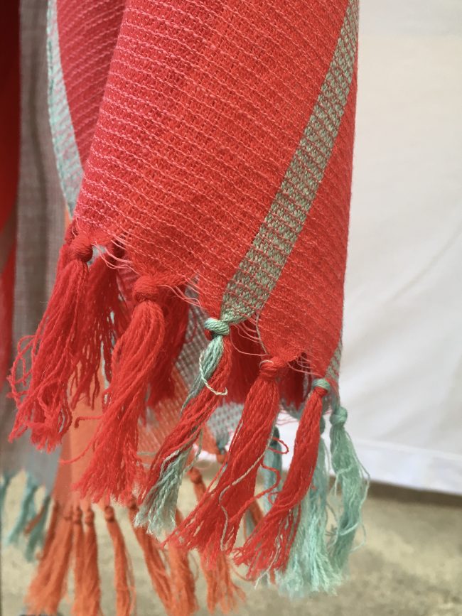 Bold, variegated stripes in tomato, orange, red and grey make up this merino wool shawl from Kilmora