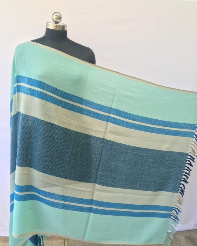 Merino wool shawl from Kilmora. In bold variegated stripes of sky blue, cerulean, grey and indigo