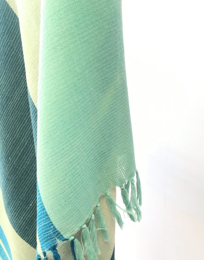 Tassles of merino wool shawl from Kilmora. In bold variegated stripes of sky blue, cerulean, grey and indigo