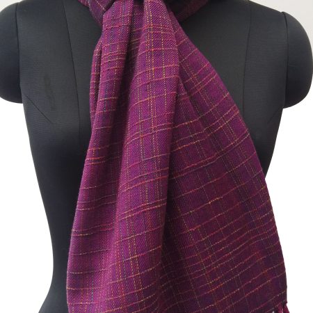 Handwoven woollen stole in a shade of rich wine purple. Patterned with random checks in light lemon yellow.