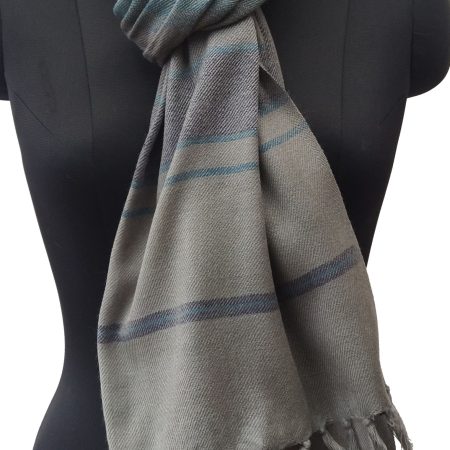 Handwoven woollen stole in graduated vertical stripes. In shades of royal blue, lead gray and silver. All muted with a silver gray running in the warp.