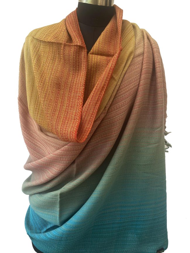handwoven merino wool shawl in gradation in shades ranging from rust to yellow to peach to pine green