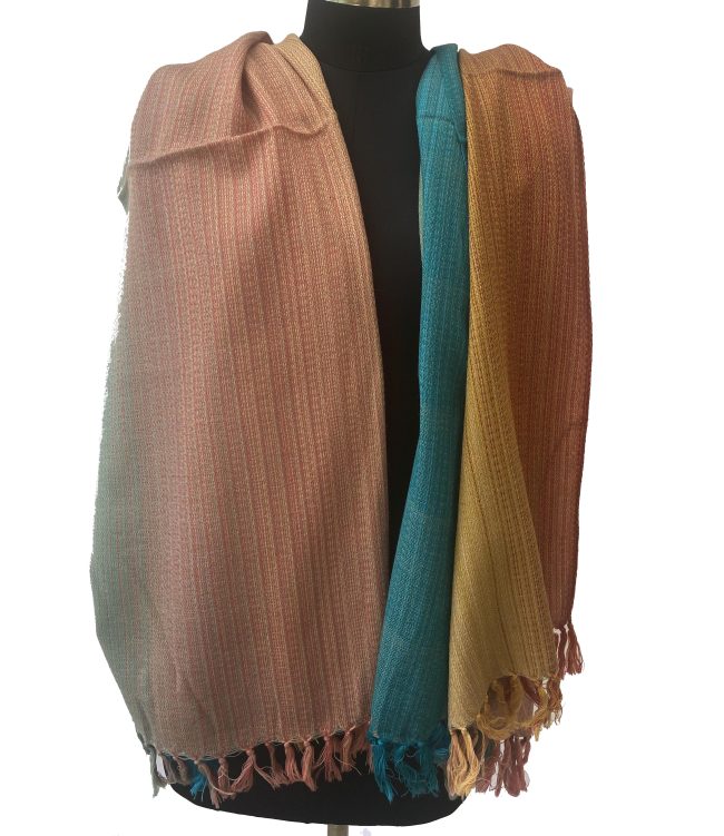 handwoven merino wool shawl in gradation in shades ranging from rust to yellow to peach to pine green
