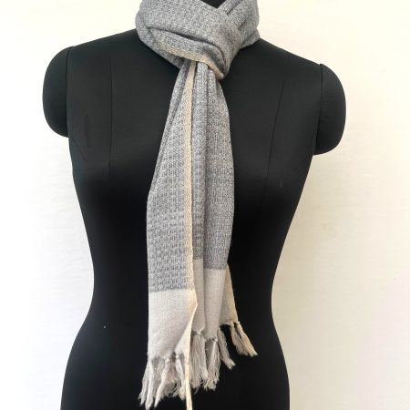 Handwoven merino wool scarf with a basket weave in black on a cream background, with a wide cream border at the end.