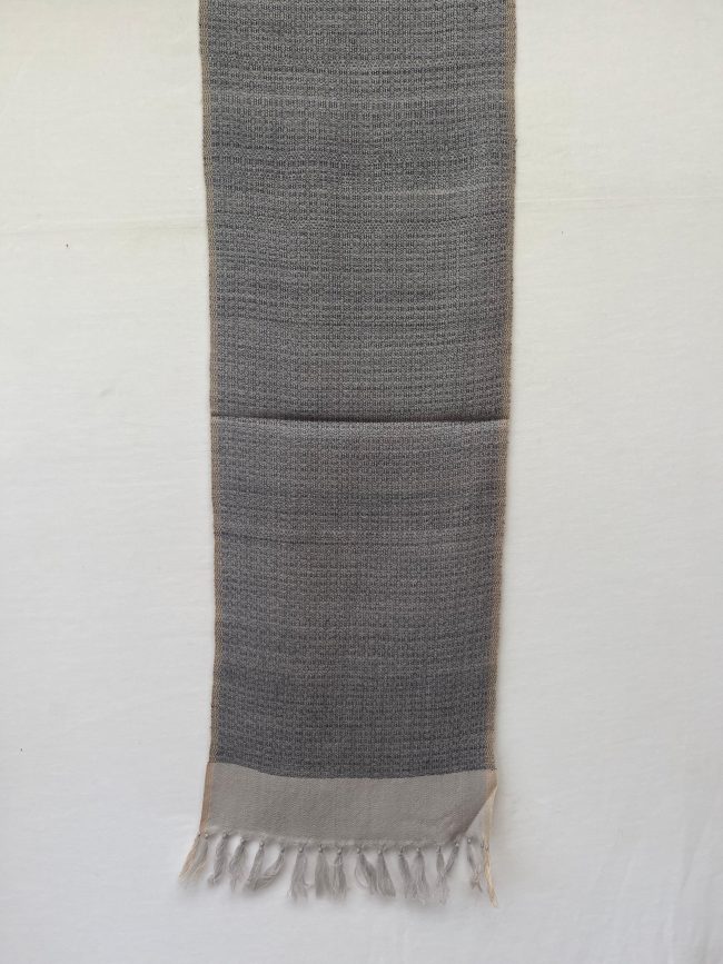 Handwoven merino wool scarf with a basket weave in black on a cream background, with a wide cream border at the end.