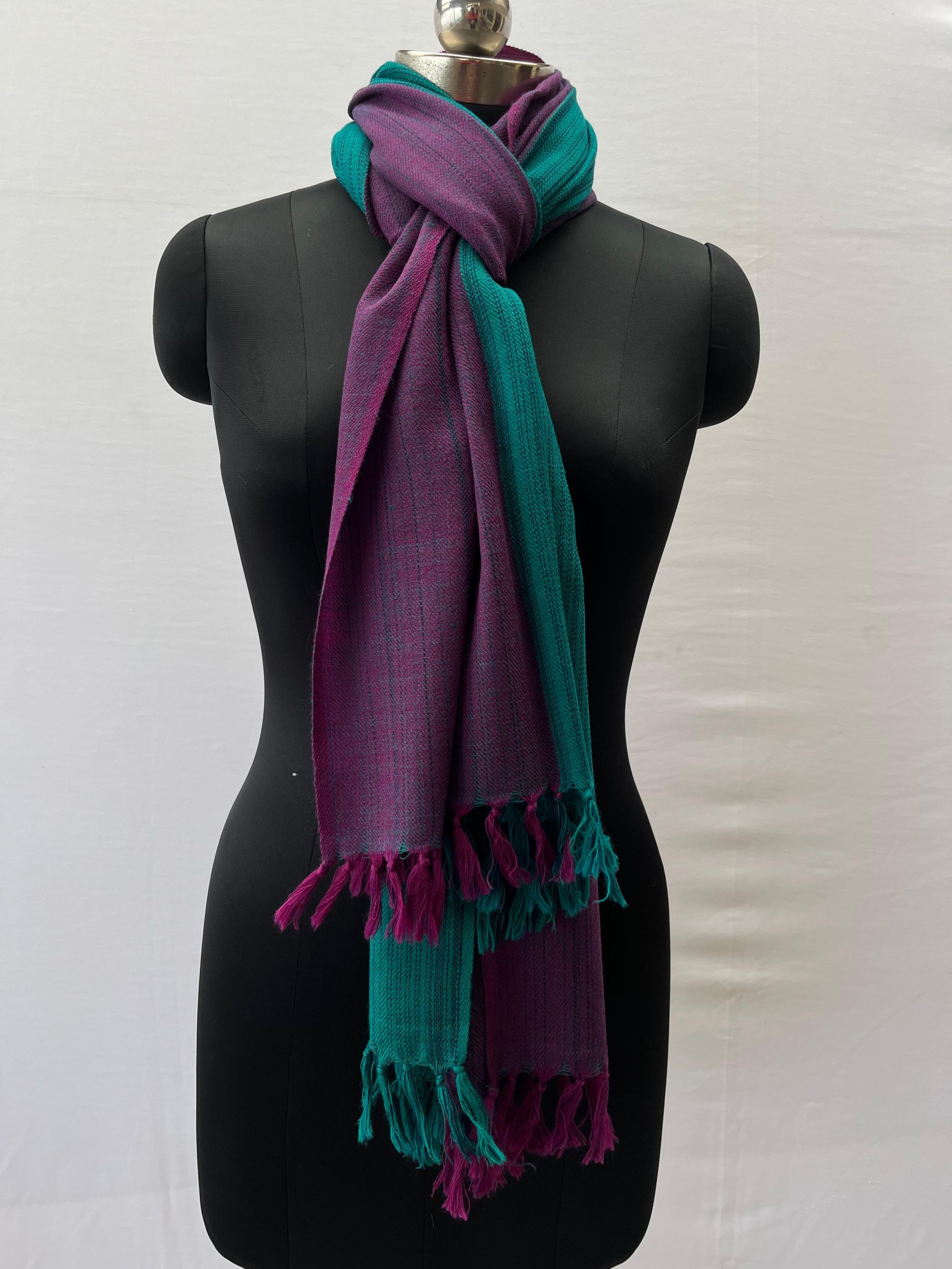 Merino wool stole knotted on a mannequin's neck. Stole is handwoven and with 2 broad vertical stripes in rich pine green and royal purple
