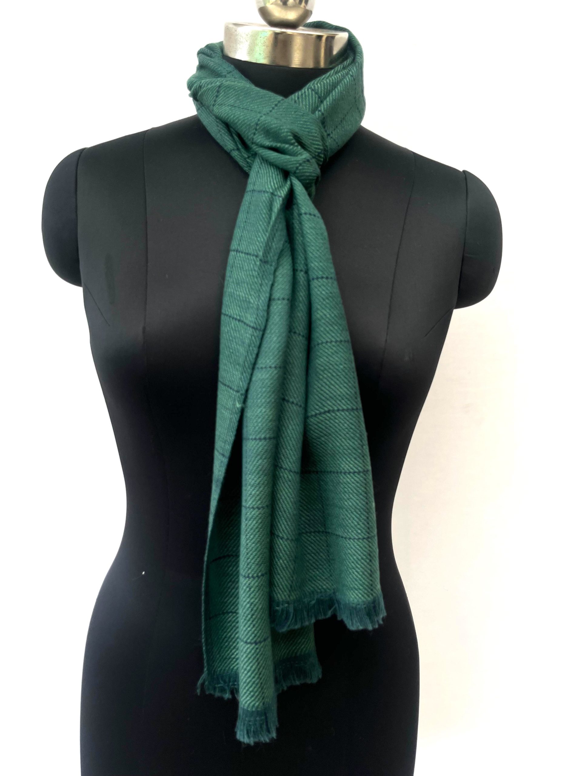 Handwoven merino wool scarf in deep pine green. Interwoven with navy blue checks.