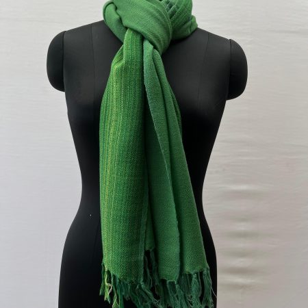 Merino wool stole knotted on a mannequin. Handwoven in fern green with a vertical border on one side