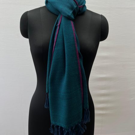 Handwoven merino wool stole knotted on a mannequin's neck. Stole is rich deep sapphire blue with a thin red selvedge