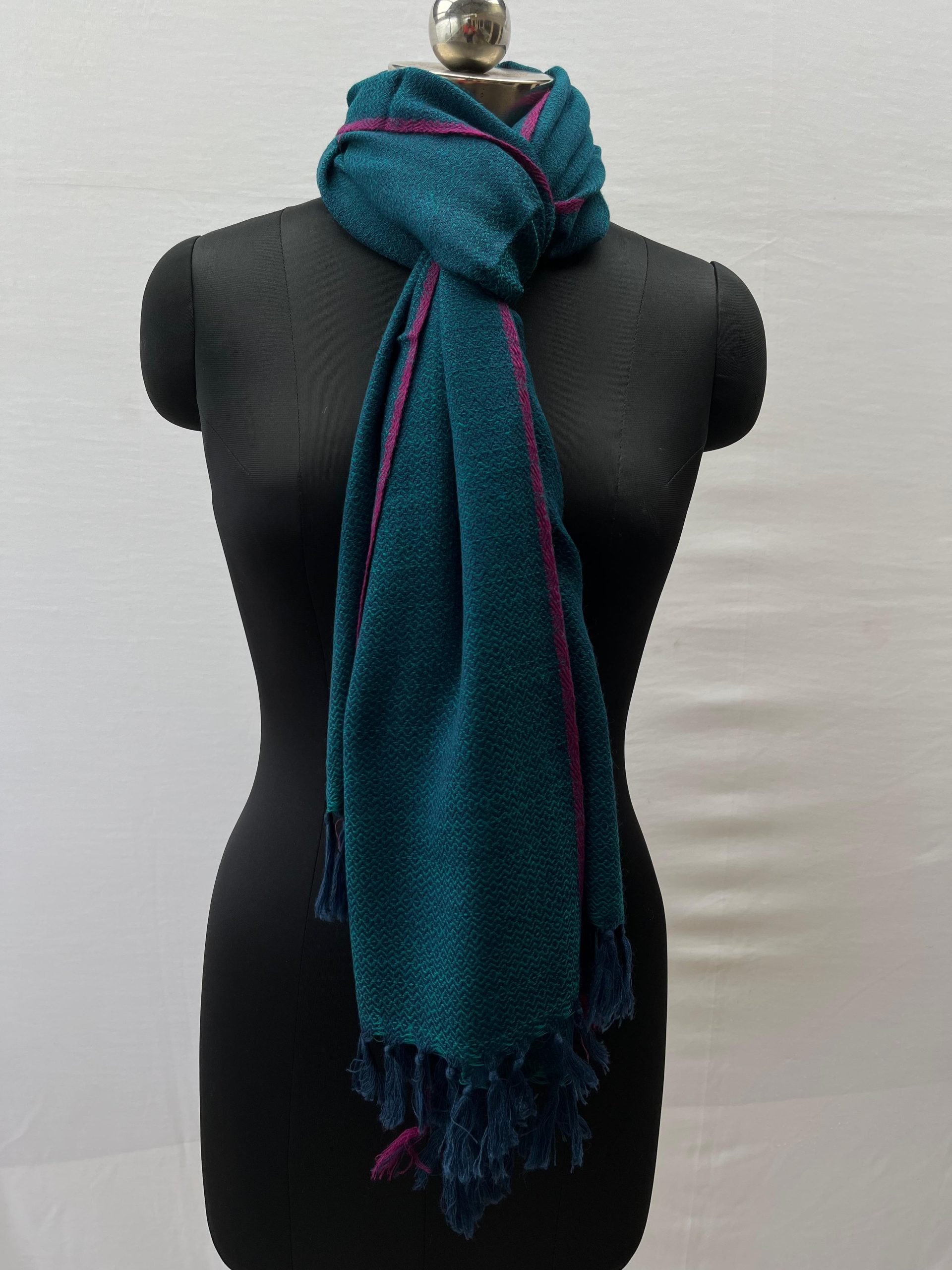 Handwoven merino wool stole knotted on a mannequin's neck. Stole is rich deep sapphire blue with a thin red selvedge