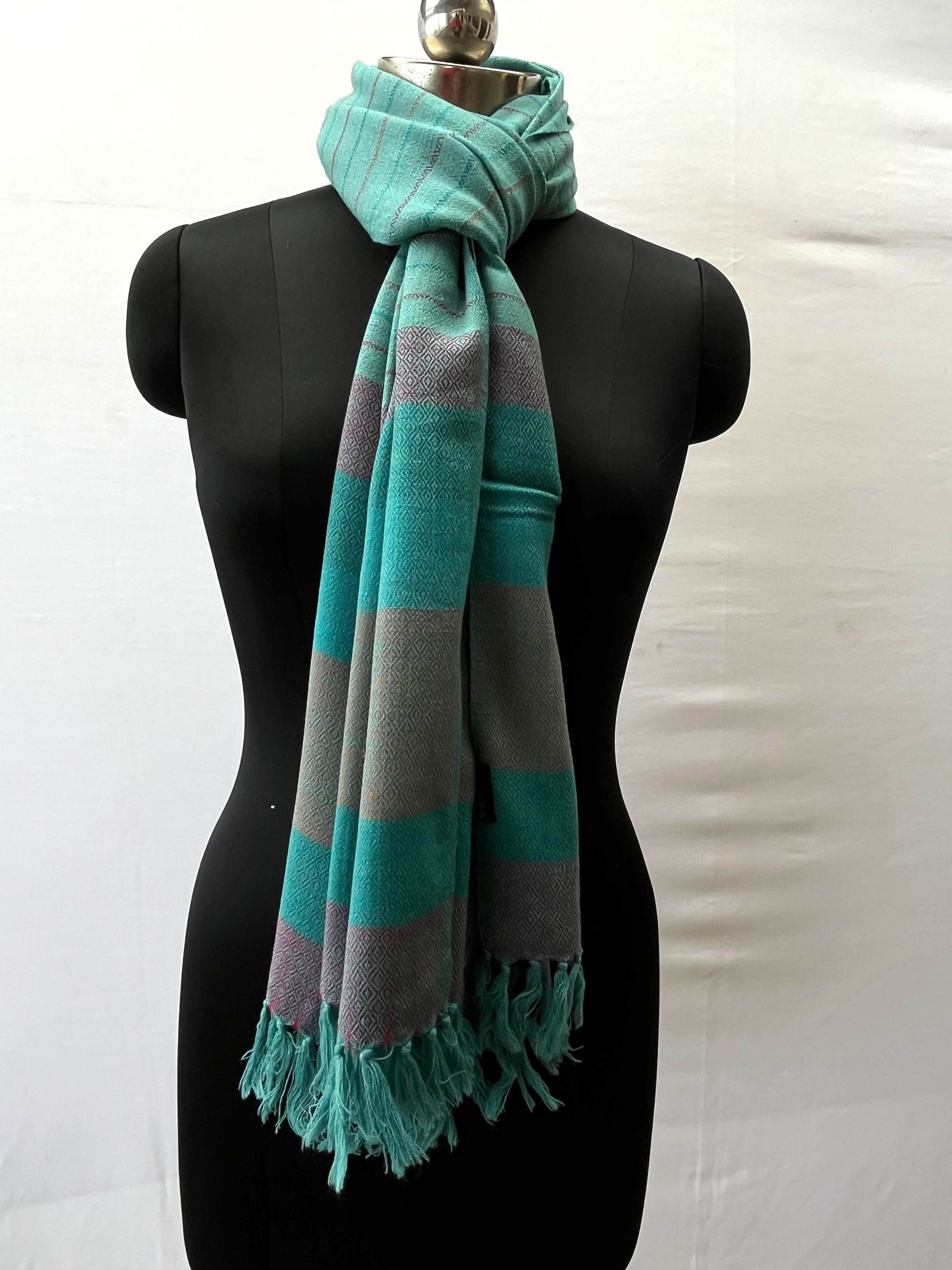 Handwoven merino wool stole in teal. With an end border of vertical stripes in red, deep green, teal, brown, deep green and ending with red