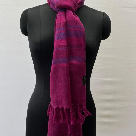 Handwoven merino wool stole woven in vertical stripes of varying widths in shades of fuchsia pink and rich purple