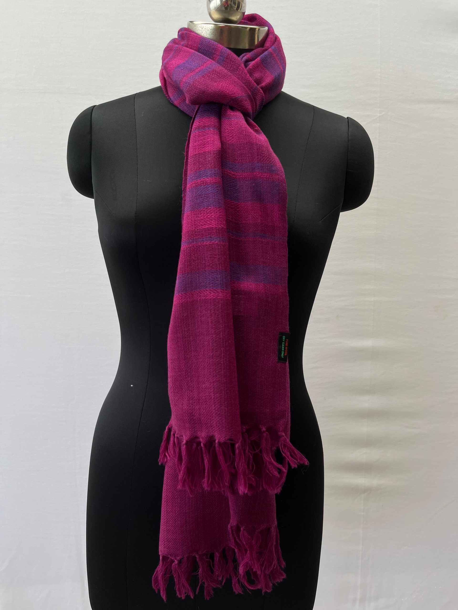Handwoven merino wool stole woven in vertical stripes of varying widths in shades of fuchsia pink and rich purple