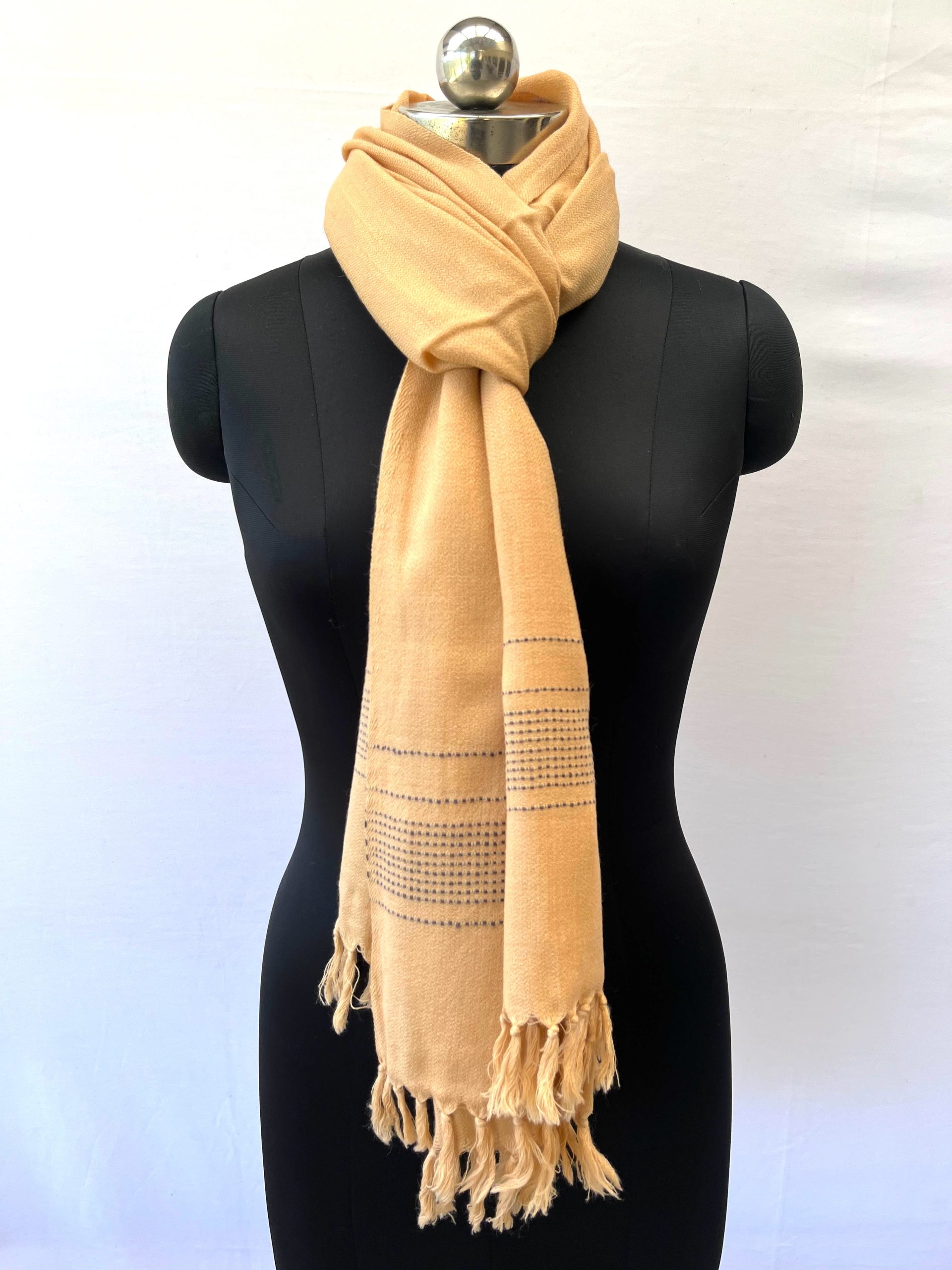 Handwoven merino wool stole in light lemon. And ends with a dotted navy blue border.