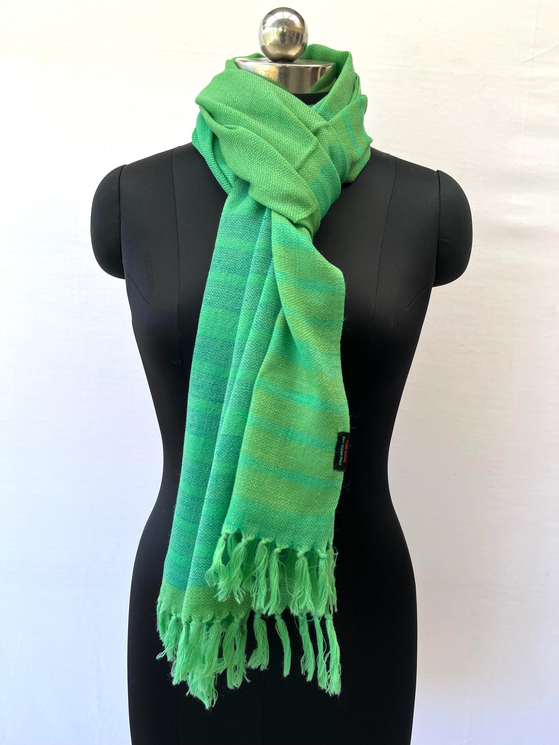 Handwoven merino wool stole in chartreuse green with 1 inch thick navy blue stripes forming a border on one side of the stole