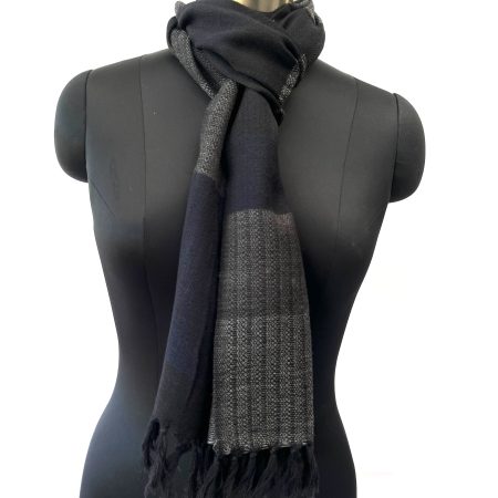 Merino wool scarf knotted on a mannequin, woven in horizontal bands of steel gray, black, lead and pewter