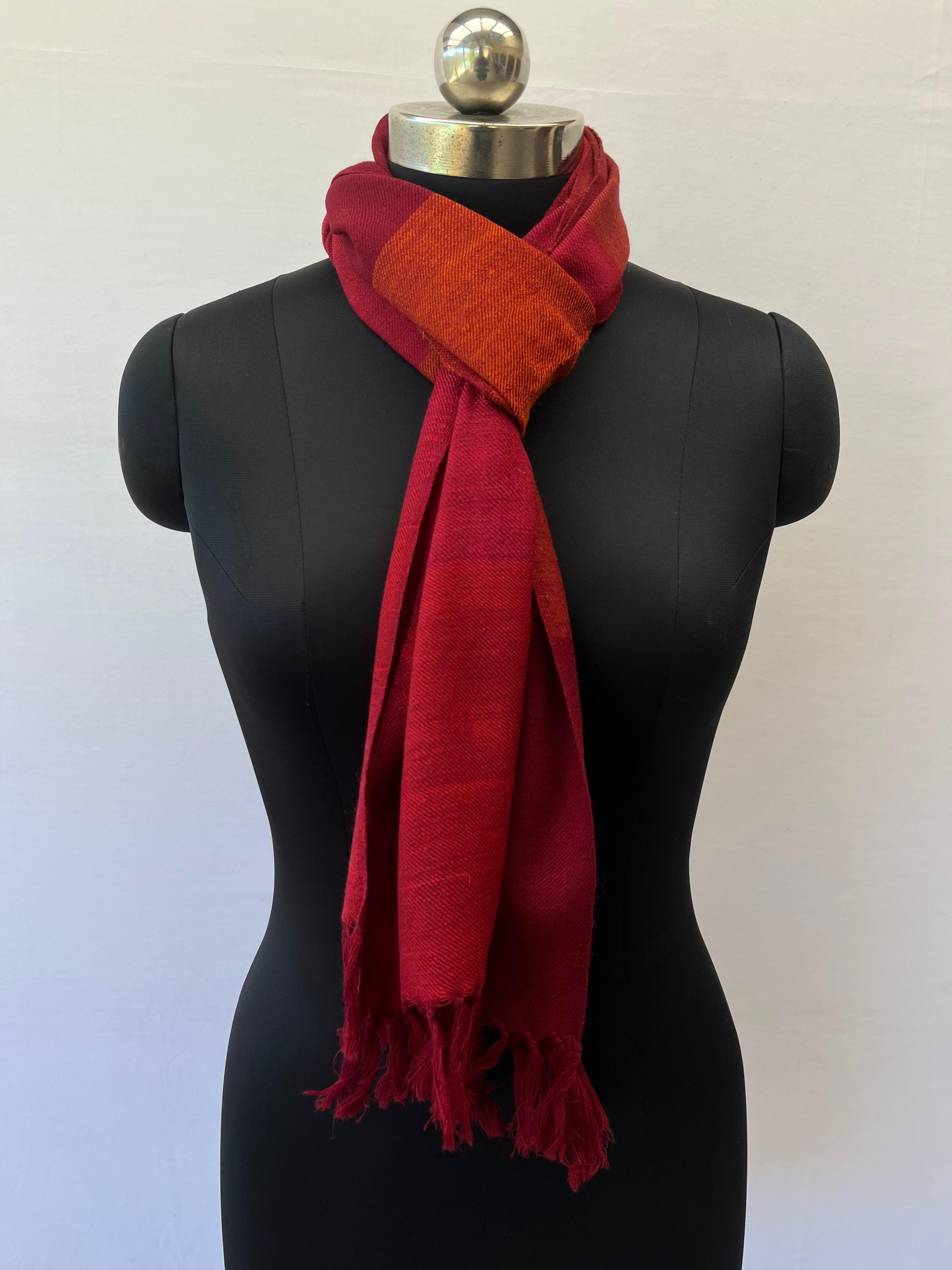 Merino wool handwoven scarf with broad stripes in cherry red, maroon and orange with a dark orange weft