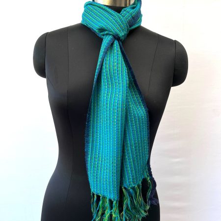Merino wool scarf with thin pin stripes in navy blue - woven over a base of teal with a thin navy blue selvedge