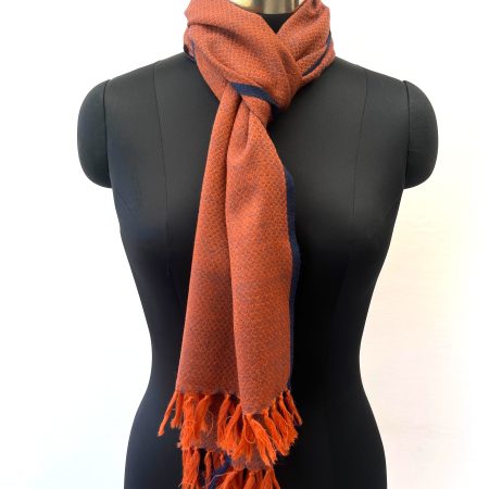 Handwoven merino wool scarf in classic diamond pattern in orange with weft of black and a thin black selvedge
