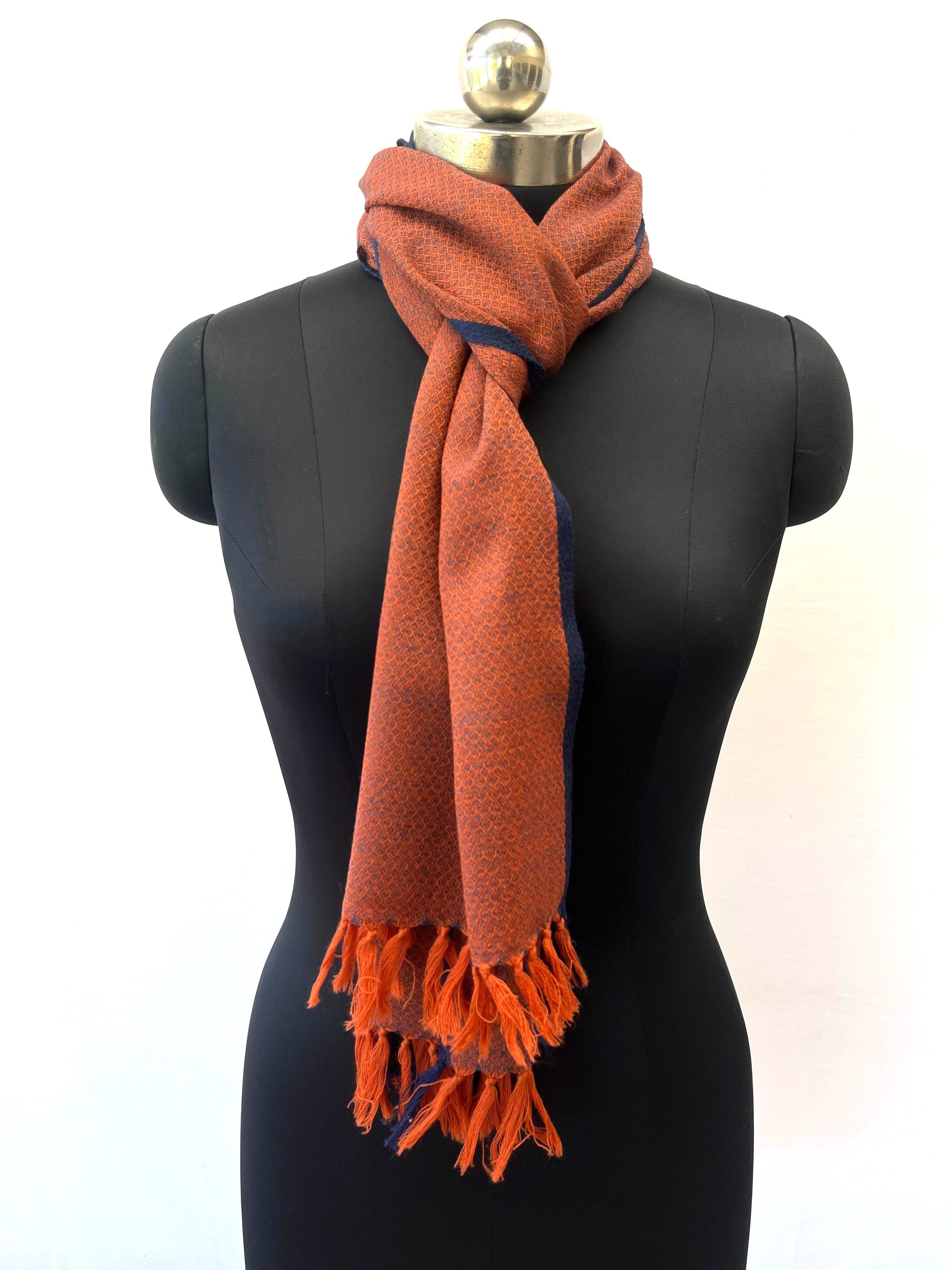 Handwoven merino wool scarf in classic diamond pattern in orange with weft of black and a thin black selvedge