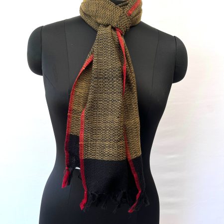 Handwoven merino wool scarf in a basket weave. In colours of deep ochre on a base of black with a thin red selvedge