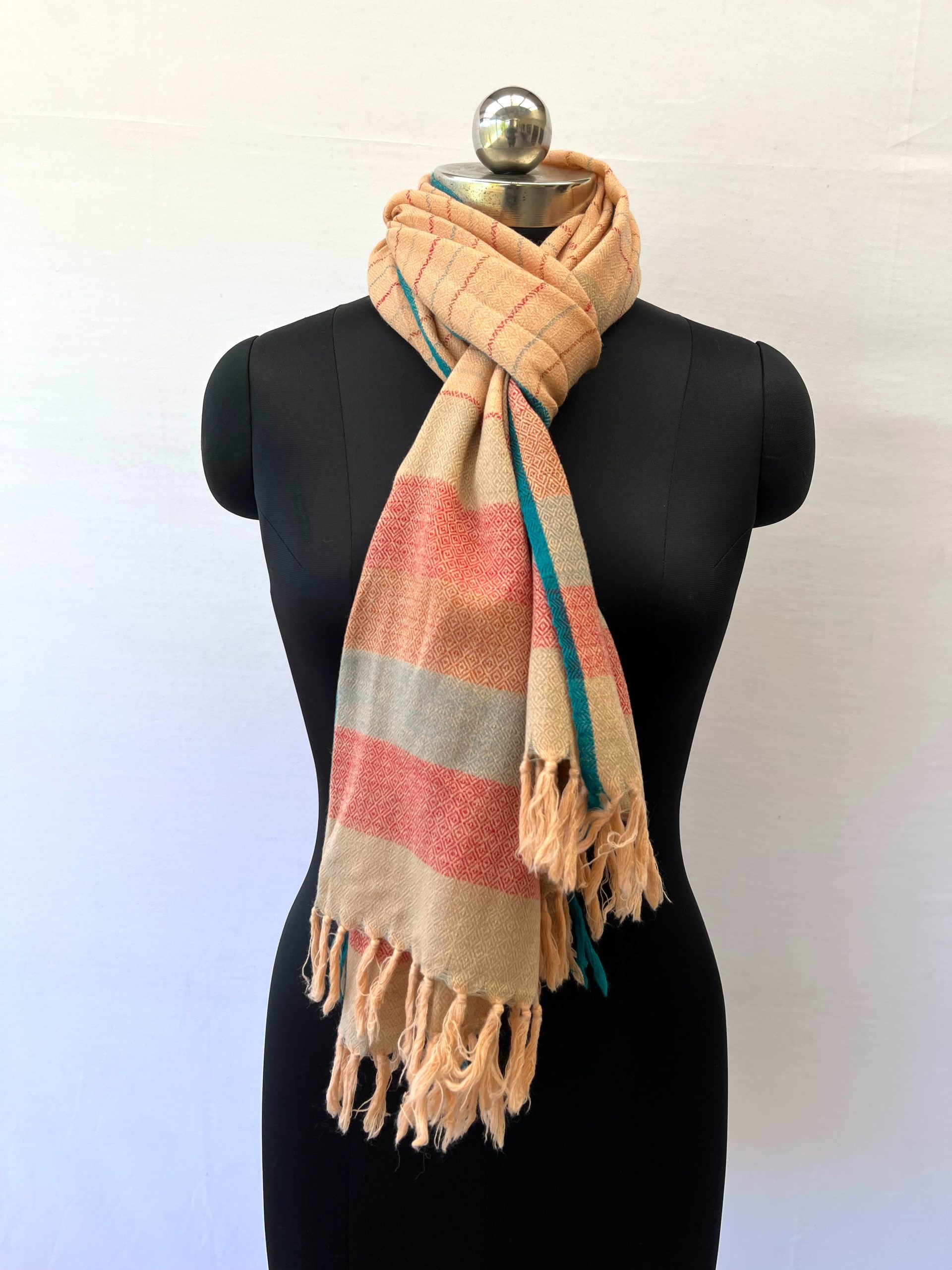 Handwoven merino wool stole in creamish yellow with thin maroon and seafood green vertical stripes. And ending with a border of seafood green and red stripes. All contained between thin cobalt blue selvedge on either side