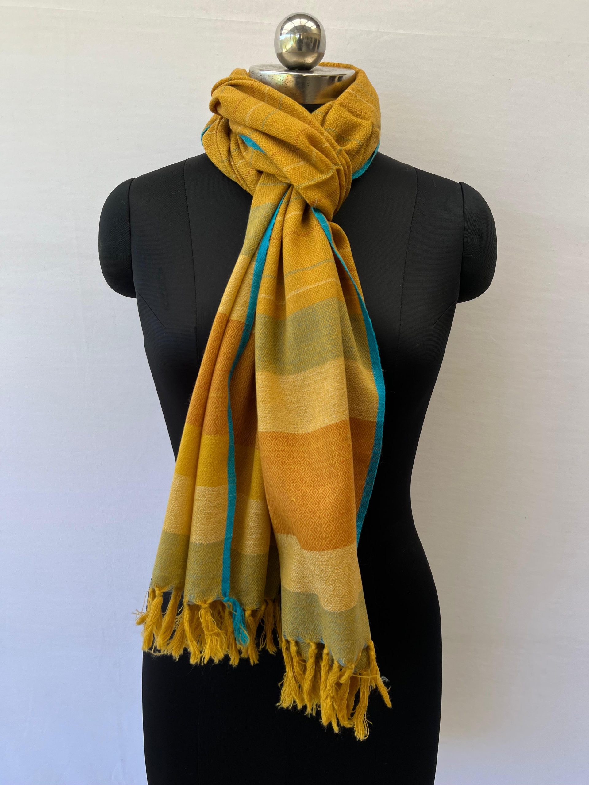 Handwoven merino wool stole in mustard yellow with thin stripes of red, yellow and seafoam green.