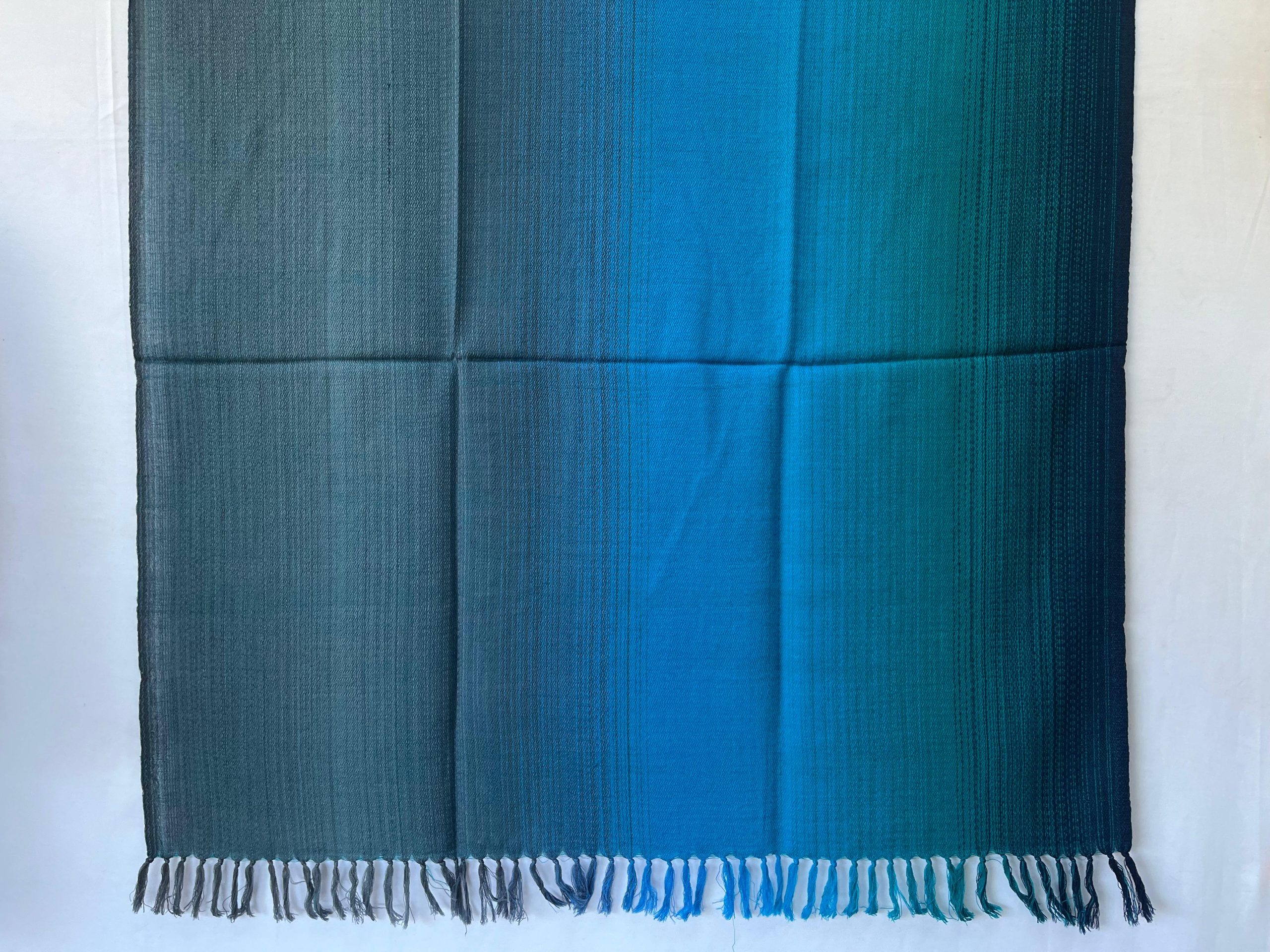 Handwoven merino wool shawl in ombre horizontal gradtion of oceanic blue, teal, turquoise and navy