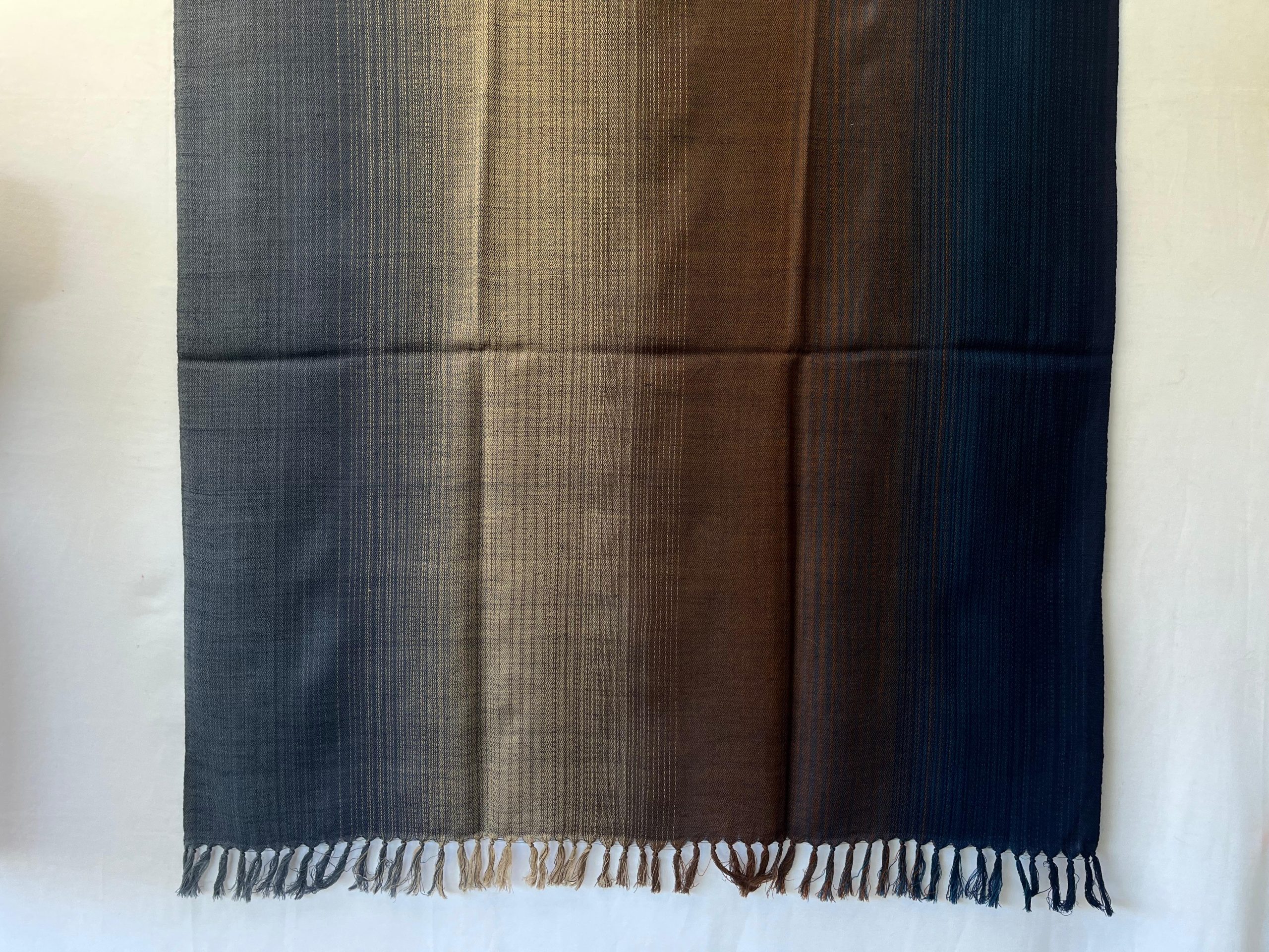 Handwoven merino wool shawl in horizontal gradation of steel blue, pewter, caramel and deep midnight blue