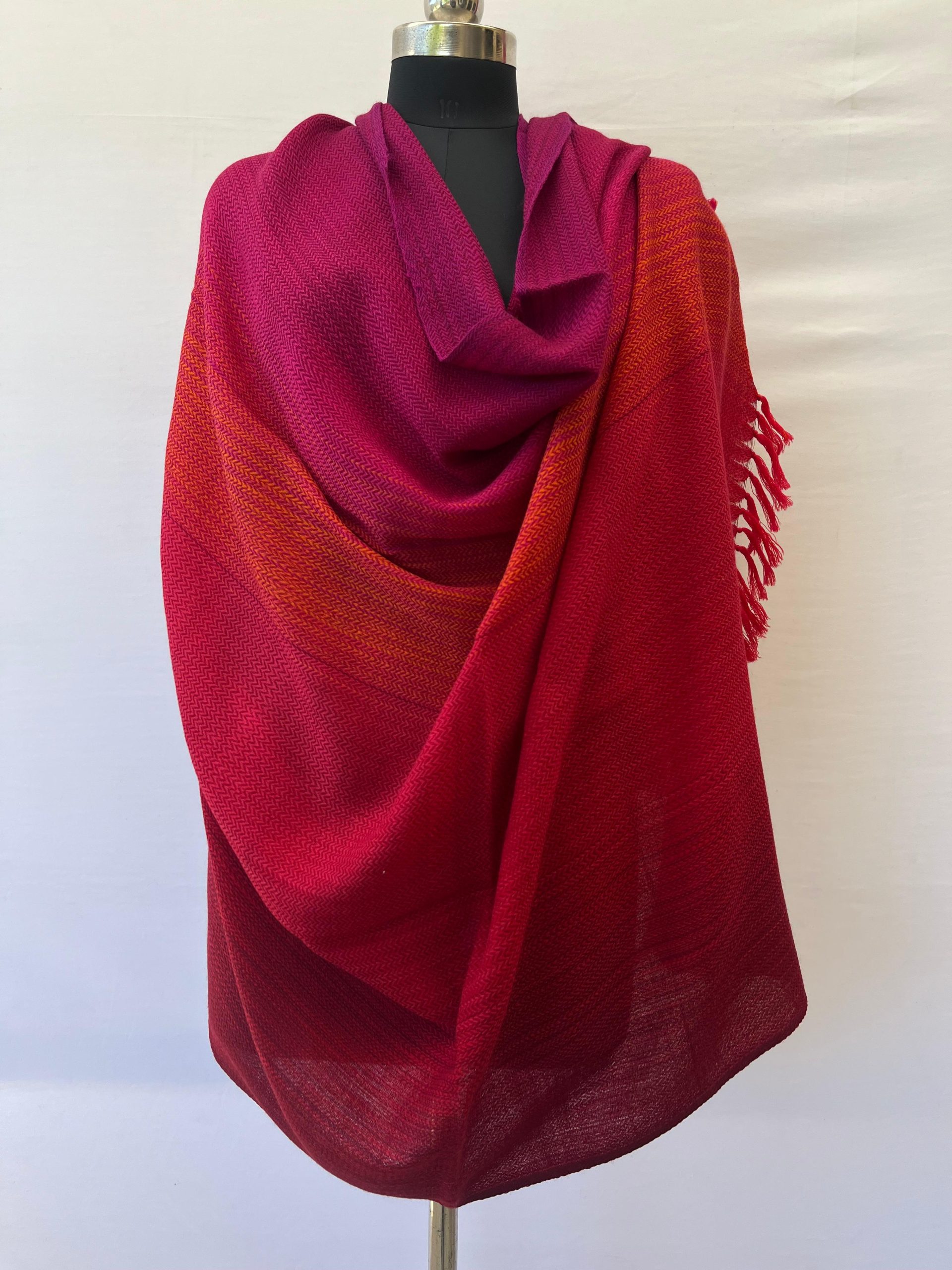Handwoven merino wool shawl in gradation with shades from bright deep magenta and ending in a deep red.