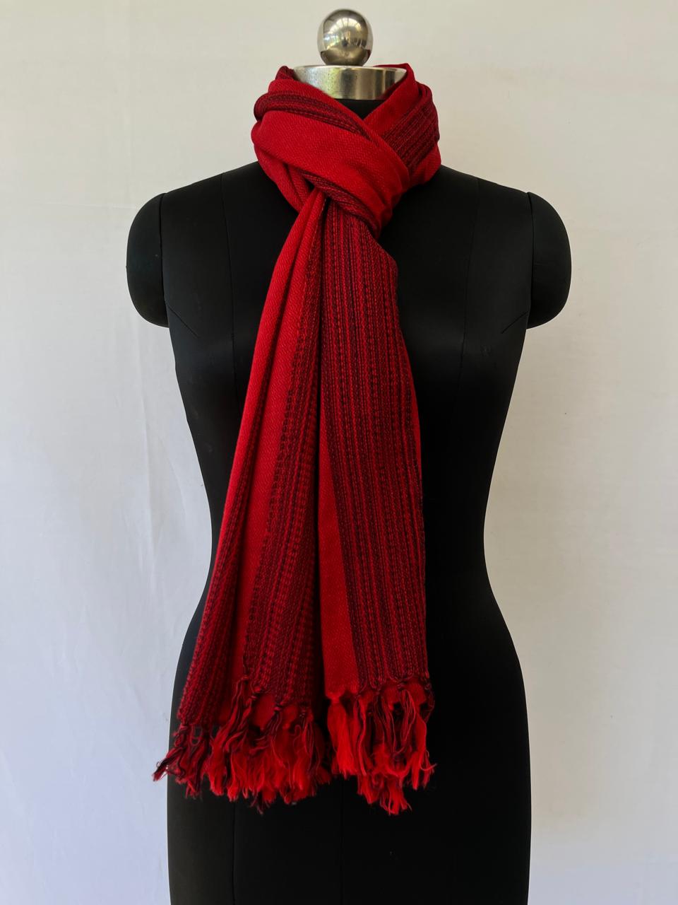 Hand-woven merino wool stole in red with asymmetric black stripes as a design element.