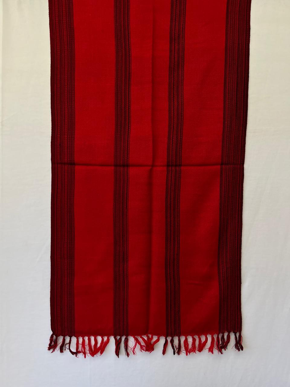 Hand-woven merino wool stole in red with asymmetric black stripes as a design element.