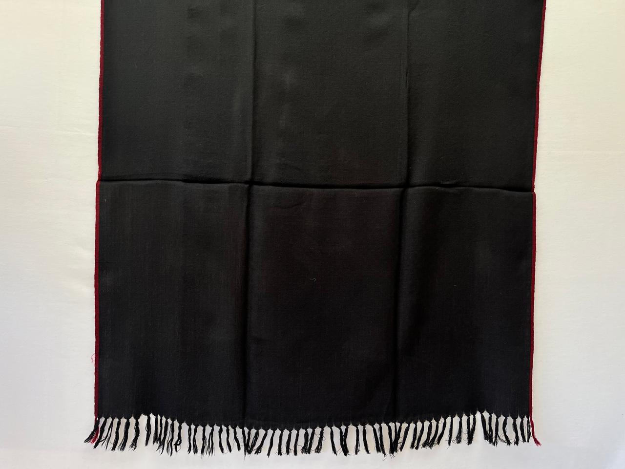 Deep blacl hand-woven merino wool shawl with a thin red selvedge