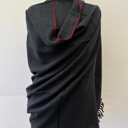 Handwoven merino wool shawl in black with white weft and a thin red selvedge